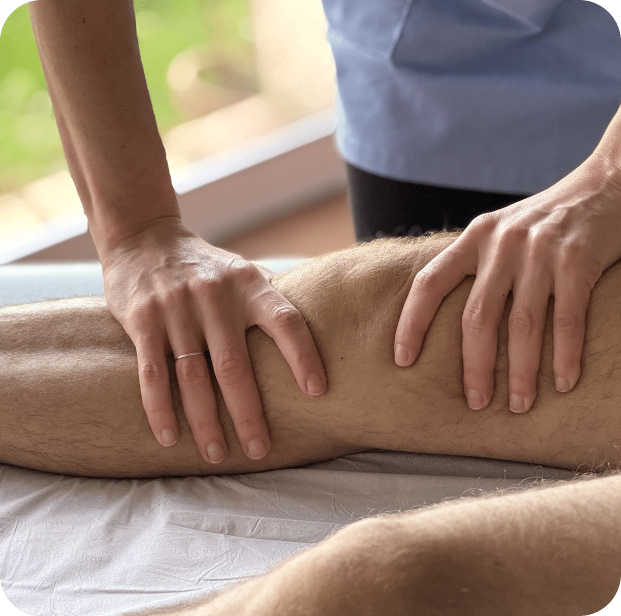 Haut-plan des mains expertes d'Anna Monlezun, ostéopathe, appliquant une technique manuelle douce sur l'articulation du genou d'un patient.